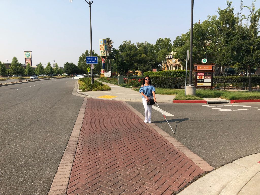 blind person at the center of the road while crossing the street