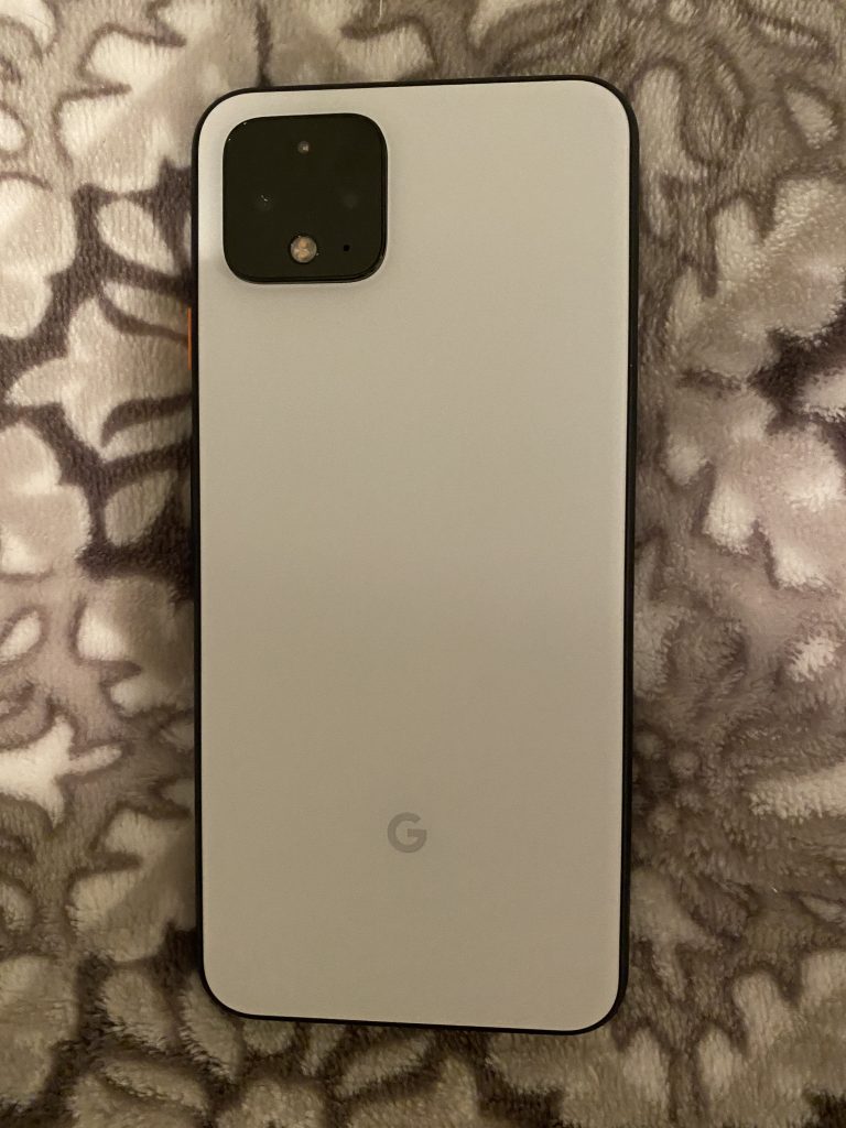 A Google Pixel smartphone placed on what appears to be a furry or fluffy surface. The phone is beige or light gold in color and has the Google "G" logo faintly visible on its back.